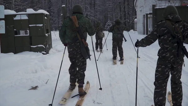 Groep soldaten uitgevoerd op ski's in de bossen met wapens. Clip. Soldaten met Ak-47 geweren en granaatwerpers loopt door het bos van de winter op de Ski's. Soldaten op oefeningen in het bos in de winter — Stockfoto