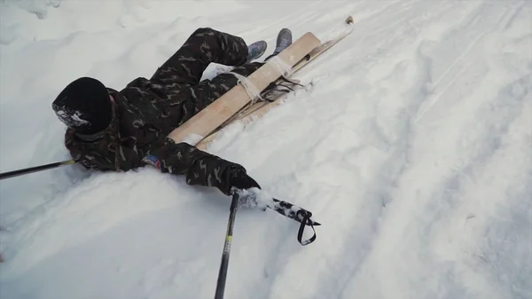 Skier setelah kecelakaan menunggu penyelamatan terbaring di salju. Jepit. Atlet ski profesional setelah kecelakaan di resort ski - konsep darurat olahraga musim dingin. Tim patroli ski menyelamatkan pemain ski yang terluka. — Stok Foto