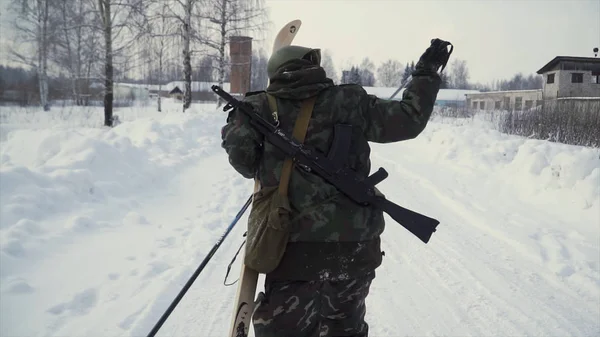 Группа солдат бежит на лыжах в лесу с оружием. Клип. Солдаты с автоматами АК-47 и гранатометами бегут по зимнему лесу на лыжах. Солдаты на учениях в лесу зимой — стоковое фото