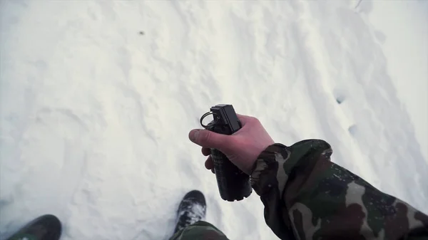 El soldado sostiene en su mano una granada de entrenamiento mientras pasa ejercicios militares en el ejército, fondo de nieve. Clip. Un soldado en camuflaje sosteniendo una granada de fragmentación en cámara lenta — Foto de Stock