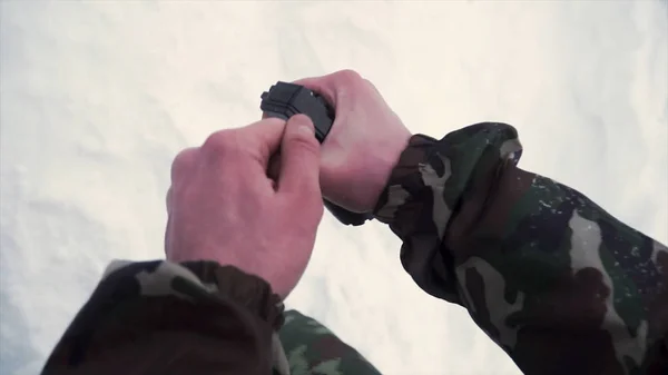 El soldado sostiene en su mano una granada de entrenamiento mientras pasa ejercicios militares en el ejército, fondo de nieve. Clip. Un soldado en camuflaje sosteniendo una granada de fragmentación en cámara lenta — Foto de Stock