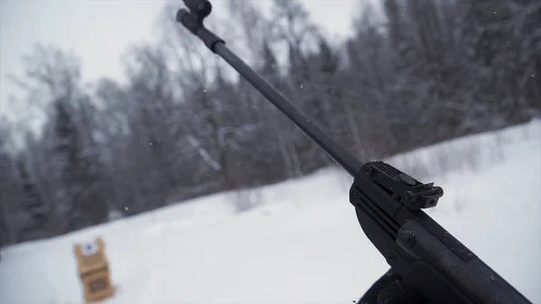 한 남자를 대상으로 펠 릿 총을 목표로 연습 하는 겨울에 그의 목표. 클립입니다. 위장에서 범인 한 광학 광경, 무기에 초점으로 소총과 대상 대상. — 스톡 사진