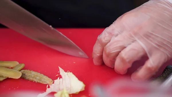 Kniven skär pickles på träskiva. Klipp. Cook skär saltgurka, kniv i kvinnliga händer, Matlagning processen, vackra små gurkor, närbild, kocken nedskärningar gurkor — Stockfoto
