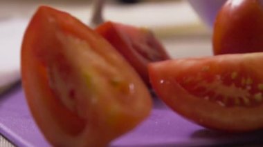 Ahşap masanın üzerine düşen Ripe domates dilimleri. Sahne. Ağır çekim. Domates dilimleri masanın üstüne düşmek