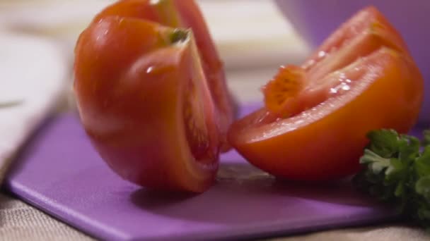 Plakjes rijpe tomaat vallen op de houten tafel. Scène. Slow-Motion. Tomaat plakjes vallen op tafel — Stockvideo