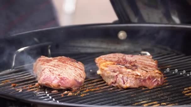 Nötköttsbiffar på grillen med flames. Matlagning biffar på kolen. Begreppet äta kött — Stockvideo