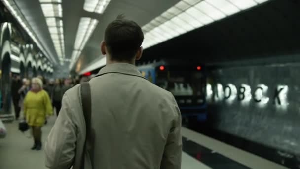 Un uomo che aspetta un treno in metropolitana. Vista posteriore di uno studente in attesa di un treno della metropolitana — Video Stock