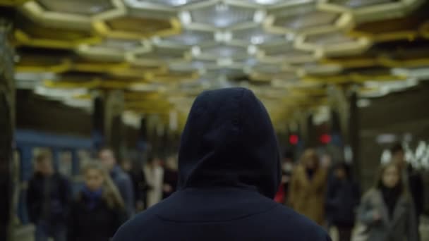 Rückansicht eines einzelnen vermummten Mannes in der U-Bahn. Konzept der Einsamkeit — Stockvideo