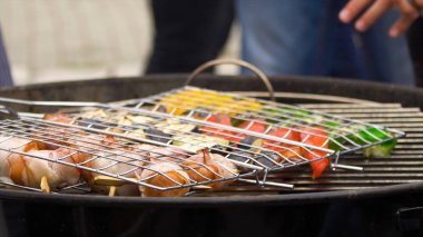 Kömürün üstünde bir barbekü üzerinde sebze ile çeşitli lezzetli ızgara sosis. Sosis ve ızgara kavrulmuş sebze