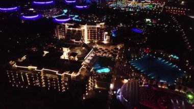 Havadan görünümü gece lüks resort otel topraklarında. Video. Otel kompleksi patikalar, avuç içi ve havuzu ile aydınlatılmış iç bölge gece manzarası. Gece üst tropikal resort otellerini göster.