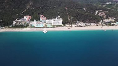 Havadan görünümü Palace veya lüks otel tarafından deniz ve dağlar arka plan üzerinde. Küçük. Uçan nefes kesici yeşil dağlık tropikal ada ve Lüks Plajı. Selectum lüks serort havadan görünümü