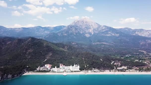 Vista aerea sul Palazzo o hotel di lusso sul mare e montagne sfondo. Clip. Volare lontano da mozzafiato verde montuosa isola tropicale e spiaggia di lusso. Vista aerea di Selectum Serort di lusso — Video Stock