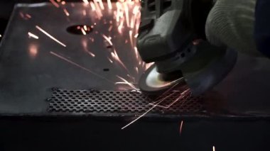 Metal parlatma disk ile bir el zımpara ile parlatma. Küçük. Fabrika işçi atölye taşlama, çelik çubuk aşındırıcı disk ve uçan ile kıvılcım. El değirmeni iş akışı oluşturma Paslanmaz boru