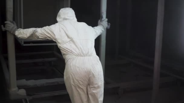 Werknemer stelt een nieuw object in de stand van de verf voor het schilderen. Clip. Schilderij booth in de fabriek. Werken in de cabine van een schilderij, handelaar Man paining industriële gereedschappen in een fabriek — Stockvideo