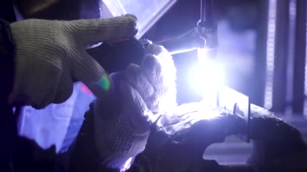 Ijzer lassen met fel licht en rook op productie. Clip. Industriële werknemer man op de fabriek lassen close-up door d'Arc — Stockvideo