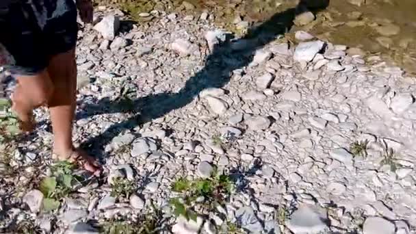 Vue arrière du jeune homme marchant sur la plage rocheuse en vacances de voyage, ensoleillé en plein air. Homme adolescent profitant de la nature, se détendre en vacances. Bien-être sain loisirs loisirs mode de vie, texture extérieure — Video