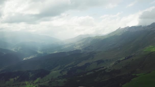 Vista a las altas montañas desde la cima de la montaña. Montañas cubiertas de bosque. Las montañas están cubiertas de bosques de coníferas con claros — Vídeos de Stock