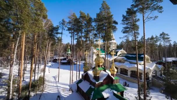 Vinter landskap med snötäckta träd mot bakgrund av en kristen kyrka efter ett snöfall. Frostiga soliga dag — Stockvideo