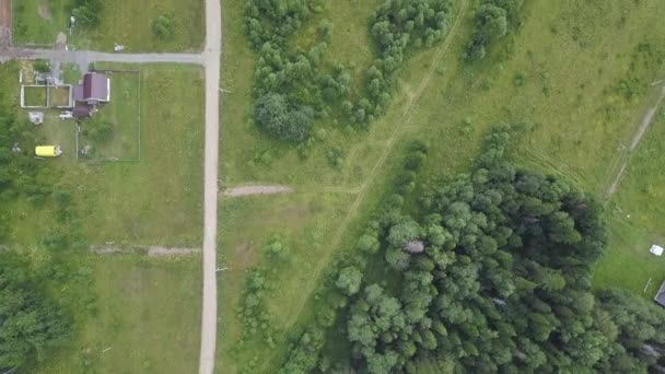 vue aérienne du dessus de la route de campagne à travers les champs et les forêts en été. Clip. Vue de dessus de la zone forestière avec route .