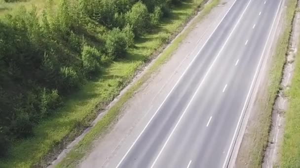 Camino que cruza bosques y formaciones rocosas. Clip. Vista superior de la carretera cerca del bosque en un día soleado — Vídeo de stock