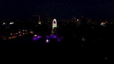 Hava gece görünümü dönme dolap ve şehir manzarası. Gece central Park'taki dönme dolap üstten görünüm. Klip.