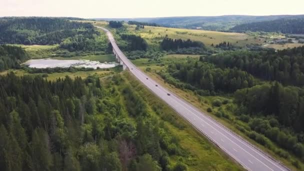 Vista aérea sobre el camino de montaña pasando por el paisaje forestal. Clip. Hermoso paisaje con carretera de montaña con coche de conducción y fondo forestal. Puesta de sol en las montañas . — Vídeos de Stock