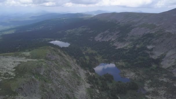 Gröna bergskedjan i moln landskap. Klipp. Ovanifrån över bergen med himmel och moln. Skogssjö i högländerna — Stockvideo