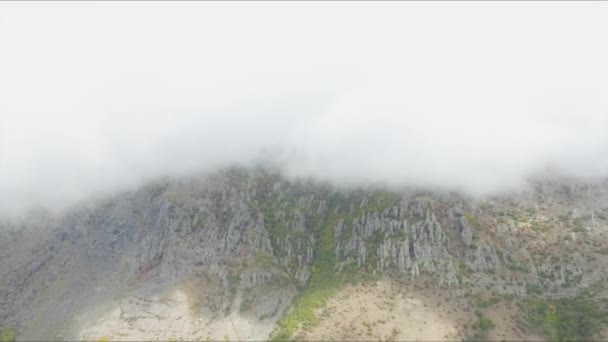 Барвистий широкий вид на глибоку зелену долину під хмарним небом. Постріл. Вид зверху на гірську місцевість під хмарами — стокове відео