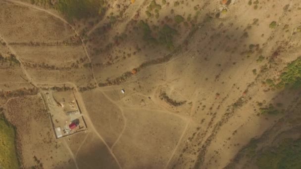 Luftaufnahme des Wüstengebiets, einer erstaunlichen geologischen Landschaft mit unglaublichen Sandformationen und Falten in der Erde. Schuss. Draufsicht auf das trockene Gebiet mit einem Haus — Stockvideo