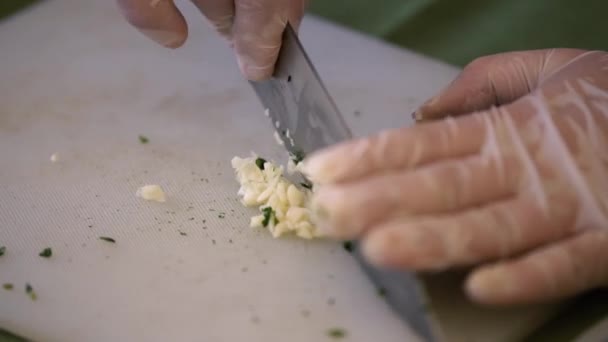 Нарізати цибулю, руки і ніж. Крупним планом шеф-кухар дрібно нарізає цибулю — стокове відео