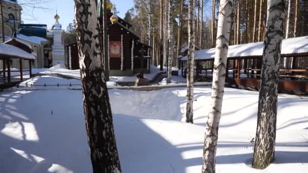 Oude kerk kantelen met witte bomen op heuvel in Russische winterseizoen. Tempel in het bos in de winter — Stockvideo