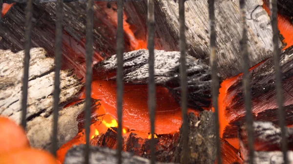 Glühend heiße Holzkohle in Grillgrube mit Flammen, Nahaufnahme. Kohlen verbrennen aus nächster Nähe — Stockfoto