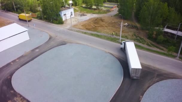 Luchtfoto van vrachtwagens geparkeerd in de voorkant van industrie gebouw. Clip. Luchtfoto. Top luchtfoto van witte Semi vrachtwagen met lading aanhangwagen met overige Trucks op speciale parkeerplaats parkeren. Luchtfoto van twee — Stockvideo