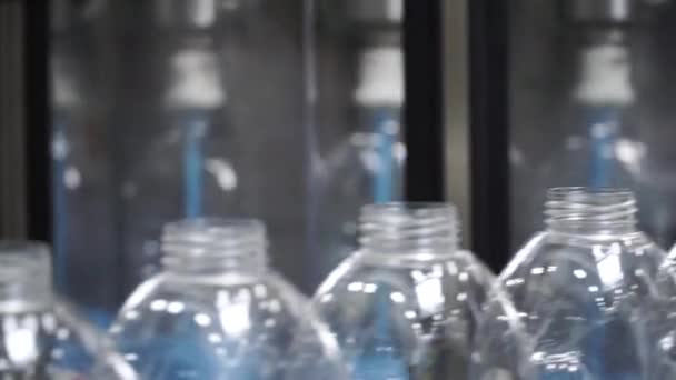 Water factory - Water bottling line for processing and bottling pure spring water into small bottles. Clip. Selective focus. Close up from a bottle industry. Close up detail of bottled water — Stock Video