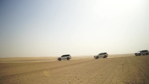 De reis van de SUV voor toeristen in de woestijn. Voorraad. Groep mensen rijden uit de wegauto in de woestijn van Vietnam tijdens een safari. Gezelschap van vrienden plezier op Duin zand. Concept van authentiek avontuur — Stockvideo