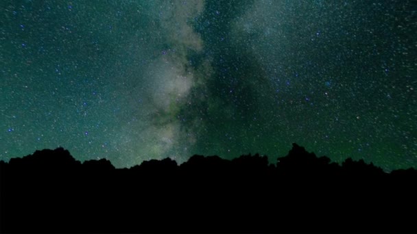 Via Láctea Time Lapse Céu noturno bonito. Time Lapse - Bela Via Láctea Galaxy acima Mountain Range. Céu noturno e estrelas, timelapse forma leitosa e brilho acima floresta de árvores, estrelas e trilhas de avião . — Vídeo de Stock