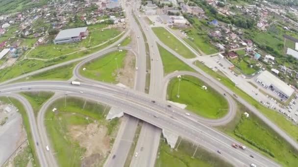 Bilar flytta om road interchange. Bilar trafiken på motorvägen korsningen. Krokig väg antenn. Flygfoto motorvägen korsningen. Motorvägen passerar i gröna fältet. Flygfoto circle road. Aerial perspektiv — Stockvideo