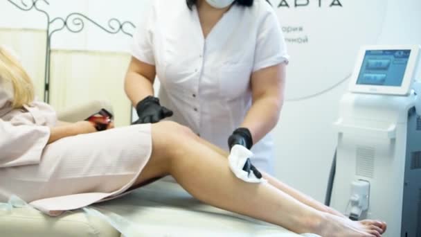 Gros plan d'une esthéticienne femme épilation jambe dans le spa de beauté. Processus d'épilation des jambes et des mains féminines dans un salon de beauté. Gros plan épilation à la cire par un esthéticien dans un centre de spa — Video