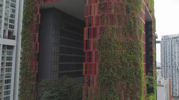 Jardins suspendus sur le rouge bel hôtel à Singapour. Fusillade. Vue de dessus du bâtiment rouge avec verdure à Singapour — Photo