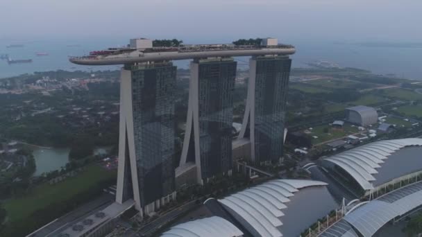 Hermosa vista superior del famoso hotel de Singapur Marina Bay Sands. Le dispararon. Tres torres de hotel de altura y una piscina en la parte superior. Arquitectura urbana moderna — Vídeos de Stock