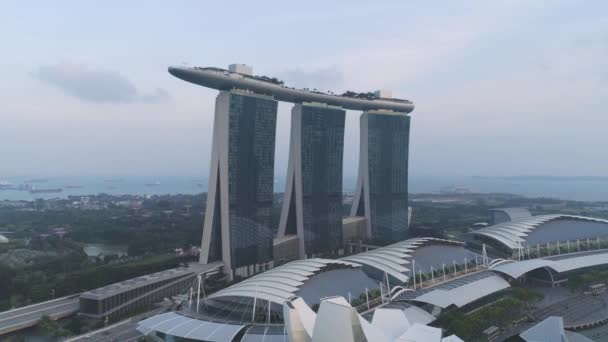 Hermosa vista superior del famoso hotel de Singapur Marina Bay Sands. Le dispararon. Tres torres de hotel de altura y una piscina en la parte superior. Arquitectura urbana moderna — Vídeos de Stock