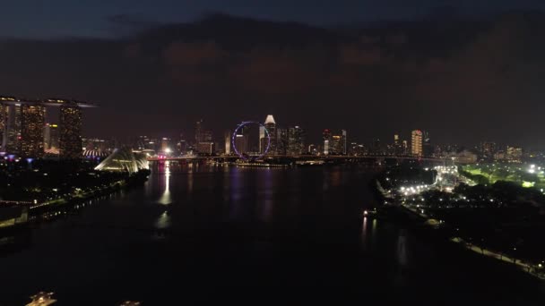 Vista aérea de Singapur por la ciudad en la noche. Le dispararon. Vista superior del río en Singapur en el área de Marina Bay por la noche — Vídeos de Stock