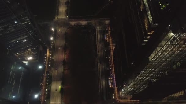 Éjszakai város, forgalom, felülnézet. Lövés. A légi felvétel a forgalmas utcán éjjel a városban. Utcai út fölé repülő — Stock videók
