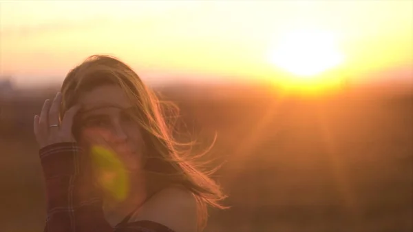 Женщина наслаждается теплым летним закатом. Красивая женщина на фоне закатных лучей солнца — стоковое фото