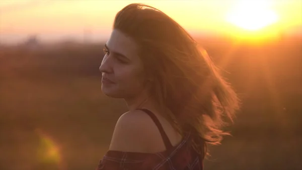 Mädchen schüttelt ihre Haare im Sommerfeld. schöne Frau schüttelt im Sonnenuntergang die Haare — Stockfoto