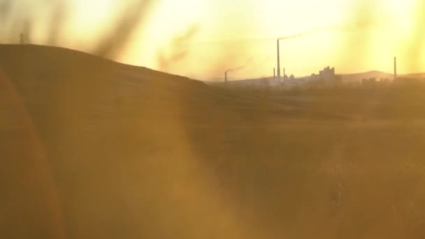 Contaminación del aire humo de tuberías y fábrica con fondo de atardecer. Planta industrial en la naturaleza al atardecer — Vídeos de Stock