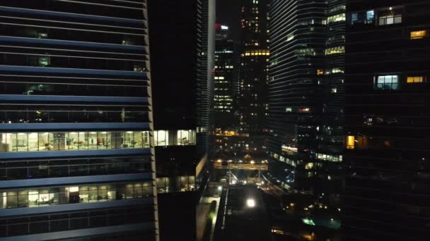 Vista de un horizonte de la ciudad con rascacielos en primer plano por la noche. Le dispararon. Vista superior de edificios de gran altura en el centro de la metrópolis por la noche — Vídeo de stock