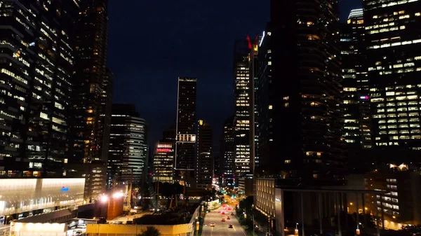 stock image Exterior picturesque modern skyscrapers with glowing windows of offices in evening. Shot. The concept of nightlife in metropolis. Top view of offices of high-rise buildin in night