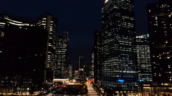 Exterior pitoresco arranha-céus modernos com janelas brilhantes de escritórios à noite. Atingido. O conceito de vida noturna em metrópole. Vista superior de escritórios de construção de arranha-céus à noite — Fotografia de Stock