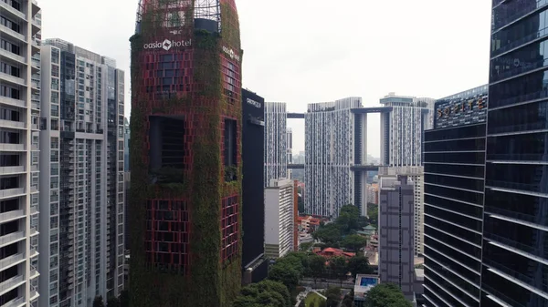 Singapore - augusti 2018: Se hög upphov office skyskrapor och privata bostadshus på Tanjong Pagar vicinity. Skott. Ovanifrån av ovanliga naturliga Oasia hotel, som står ut mot — Stockfoto